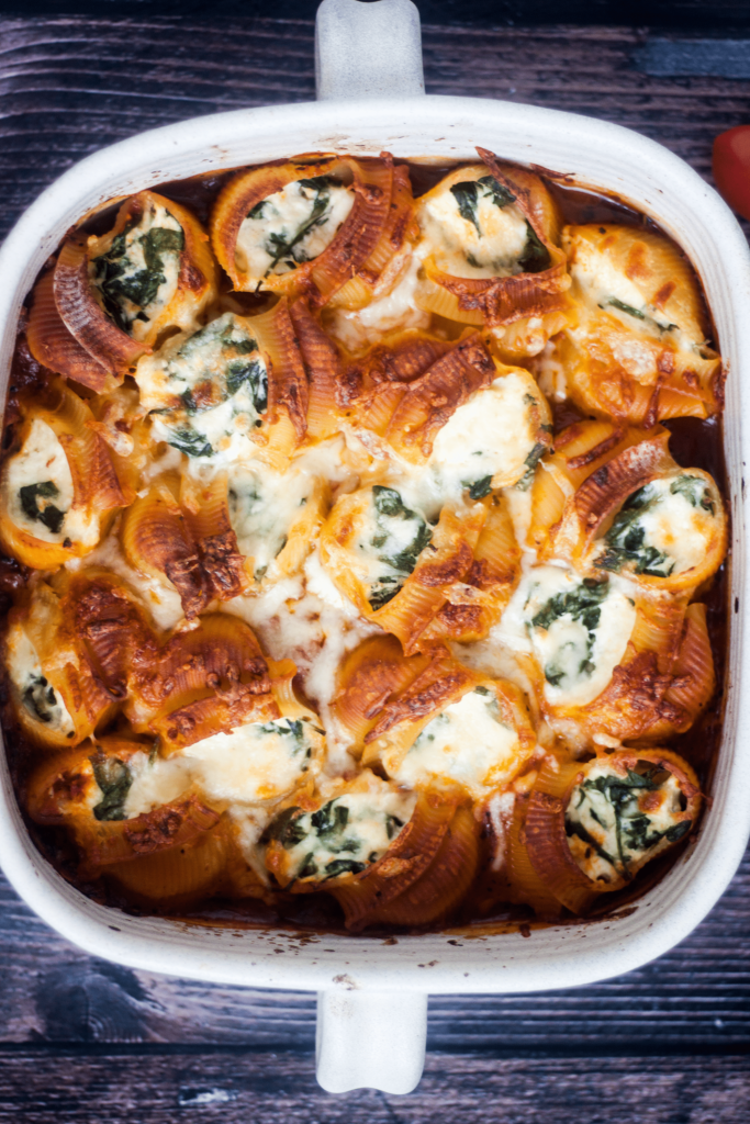 ricotta and spinach stuffed shells in baking dish on brown background