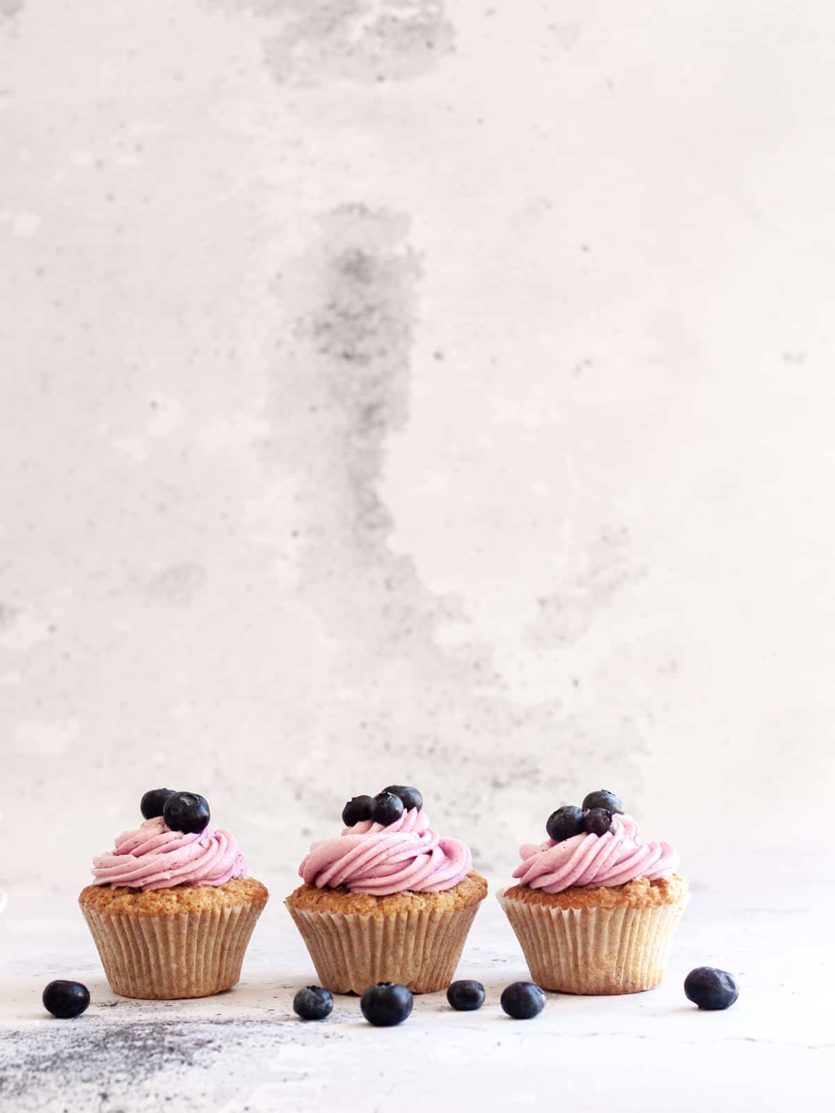 three Earl Grey Cupcakes with Blueberry Frosting
