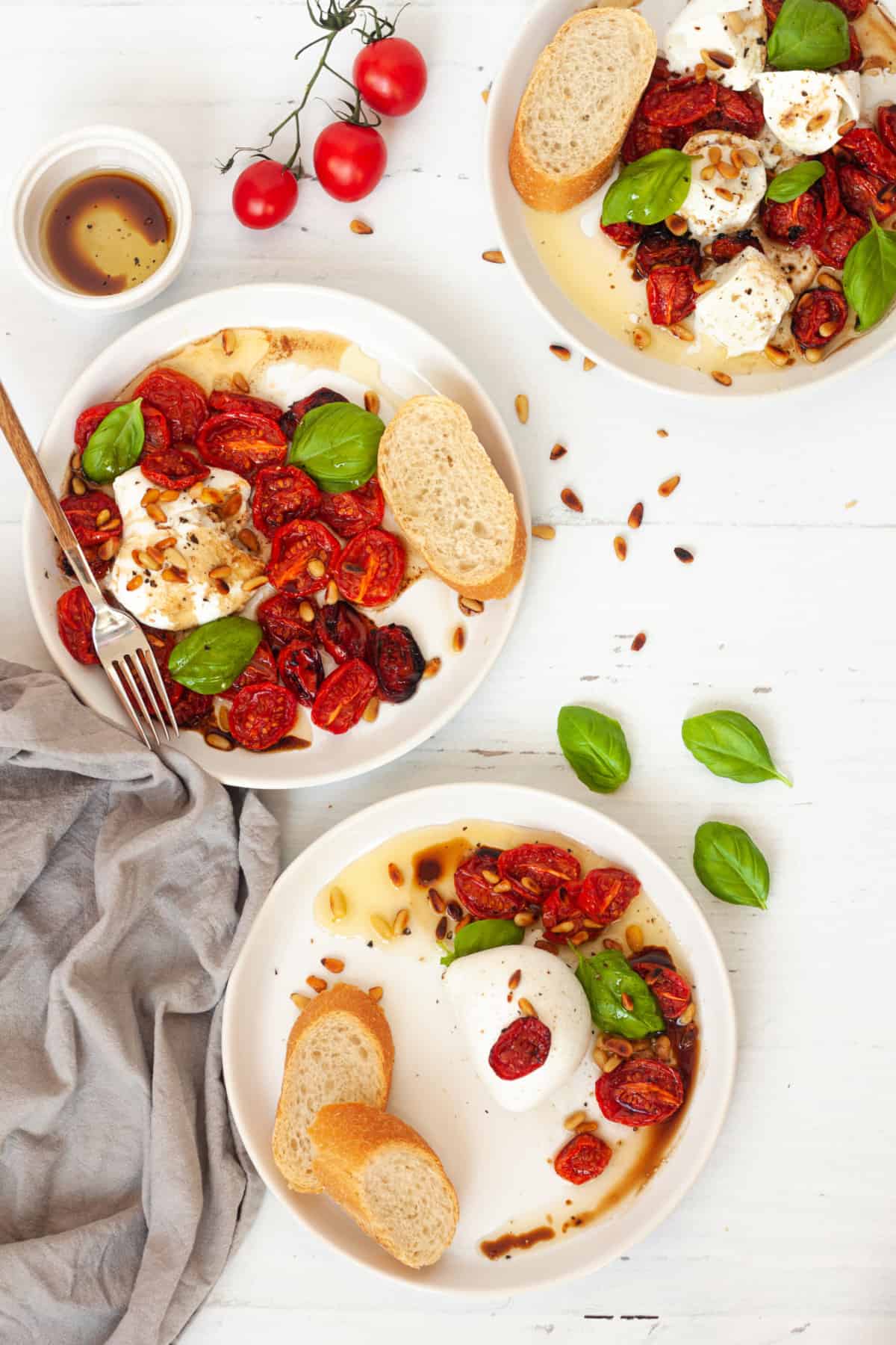 three plates of Roasted Tomatoes Buffalo Mozzarella and Pine Nut Appetizer on a white background
