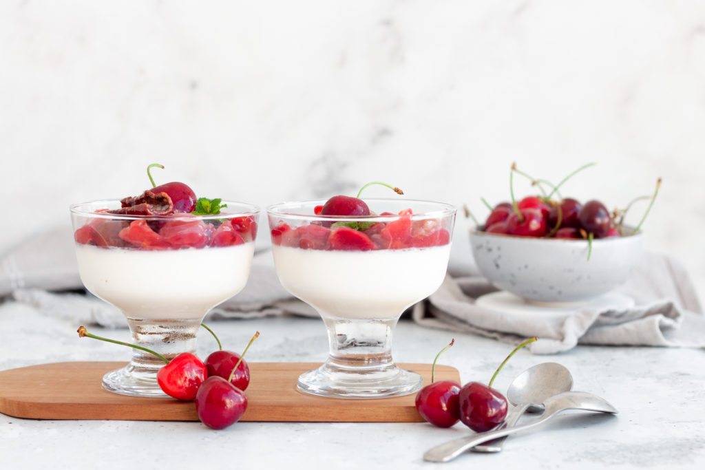 two Cherry Panna Cotta servings on a serving board