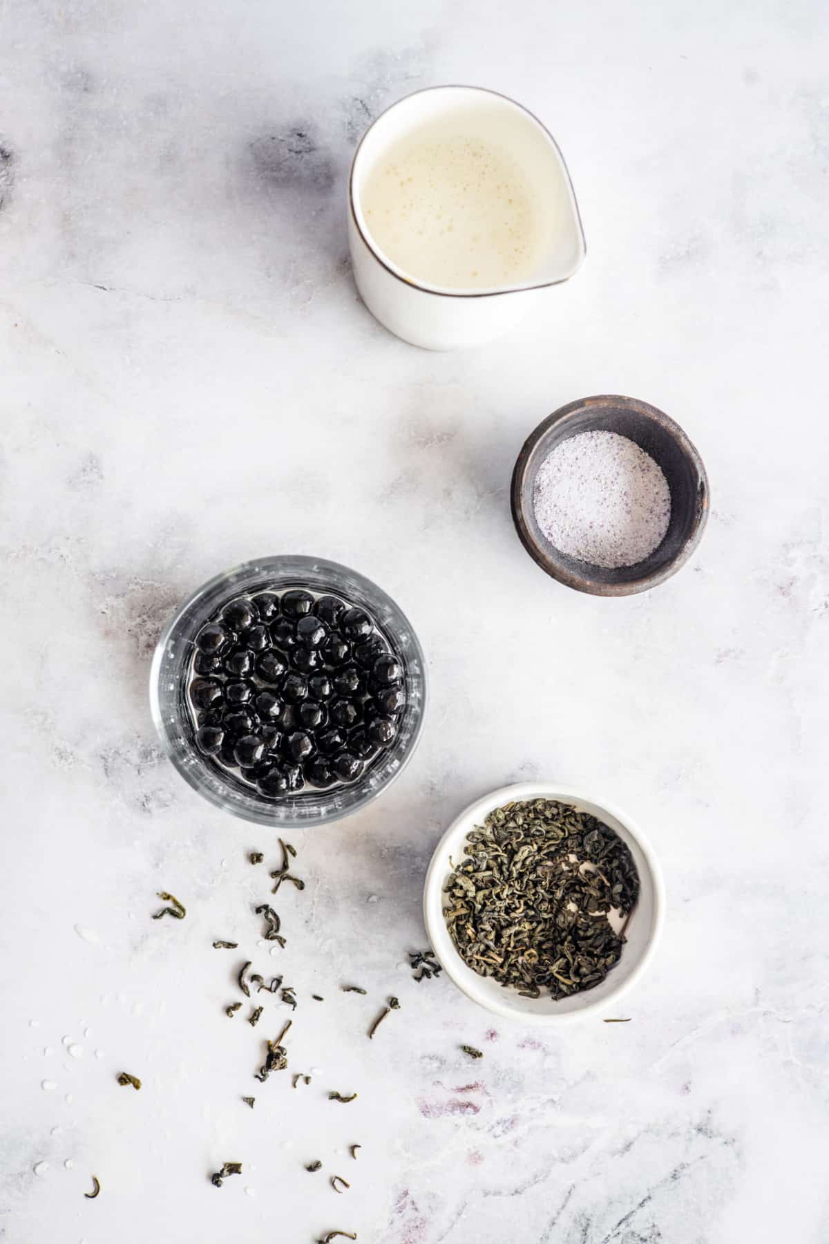 Ingredients for taro milk tea: taro powder, milk, boba pearls (optional), and Jasmine green tea leaves.