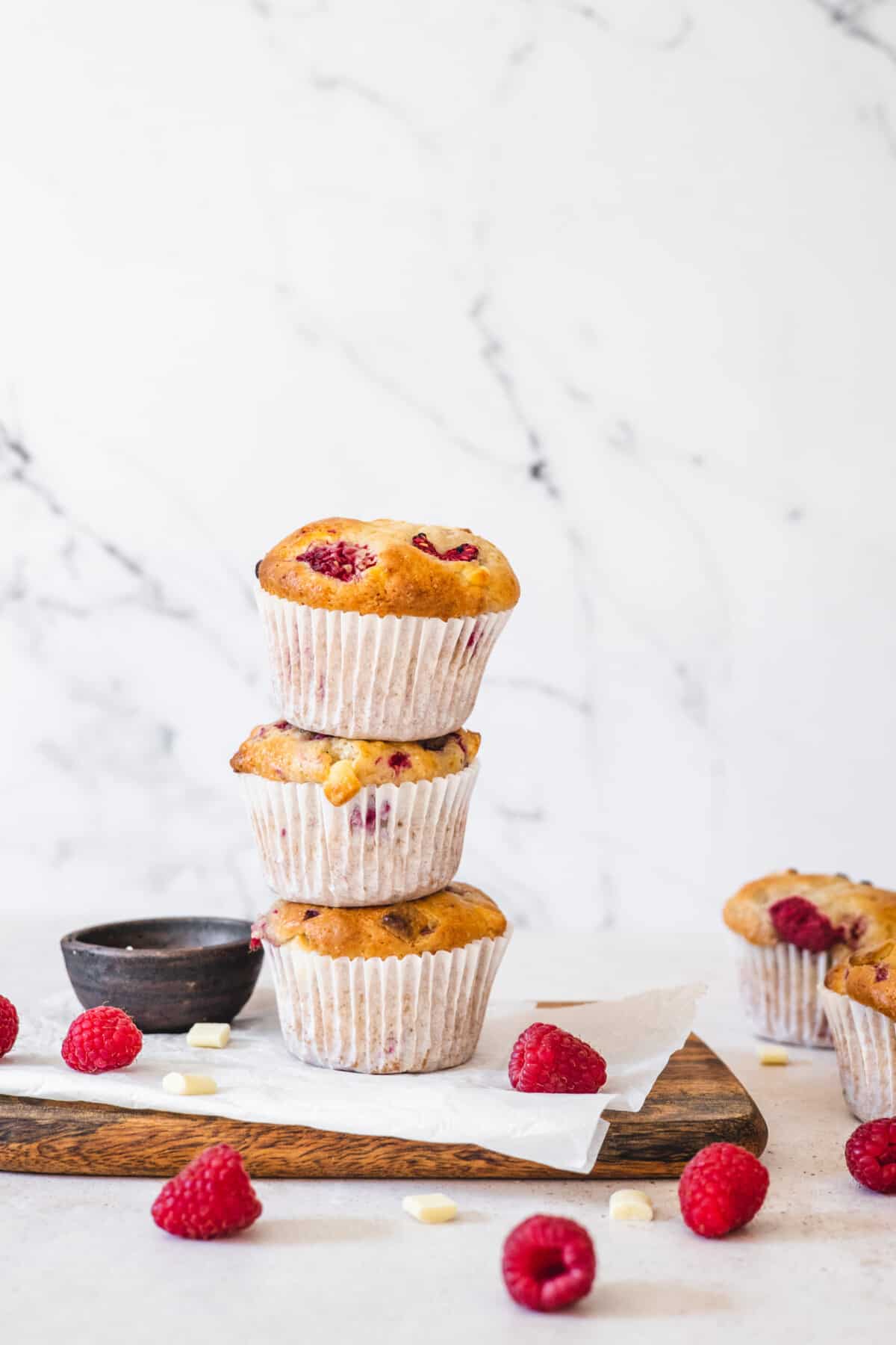 A stack of 3 white chocolate raspberry muffins.