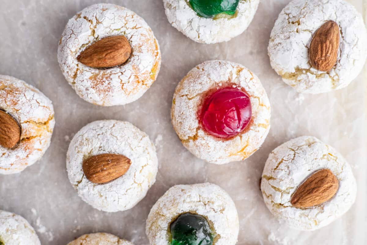 A batch of Sicilian Almond Cookies topped with candied cherries and almonds