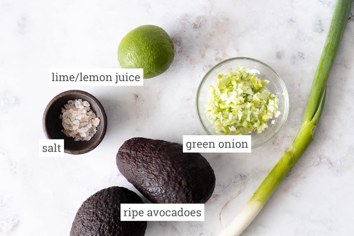 Ingredients for 4-ingredient guacamole: lime/lemon juice, ripe avocados, green onion, and salt.