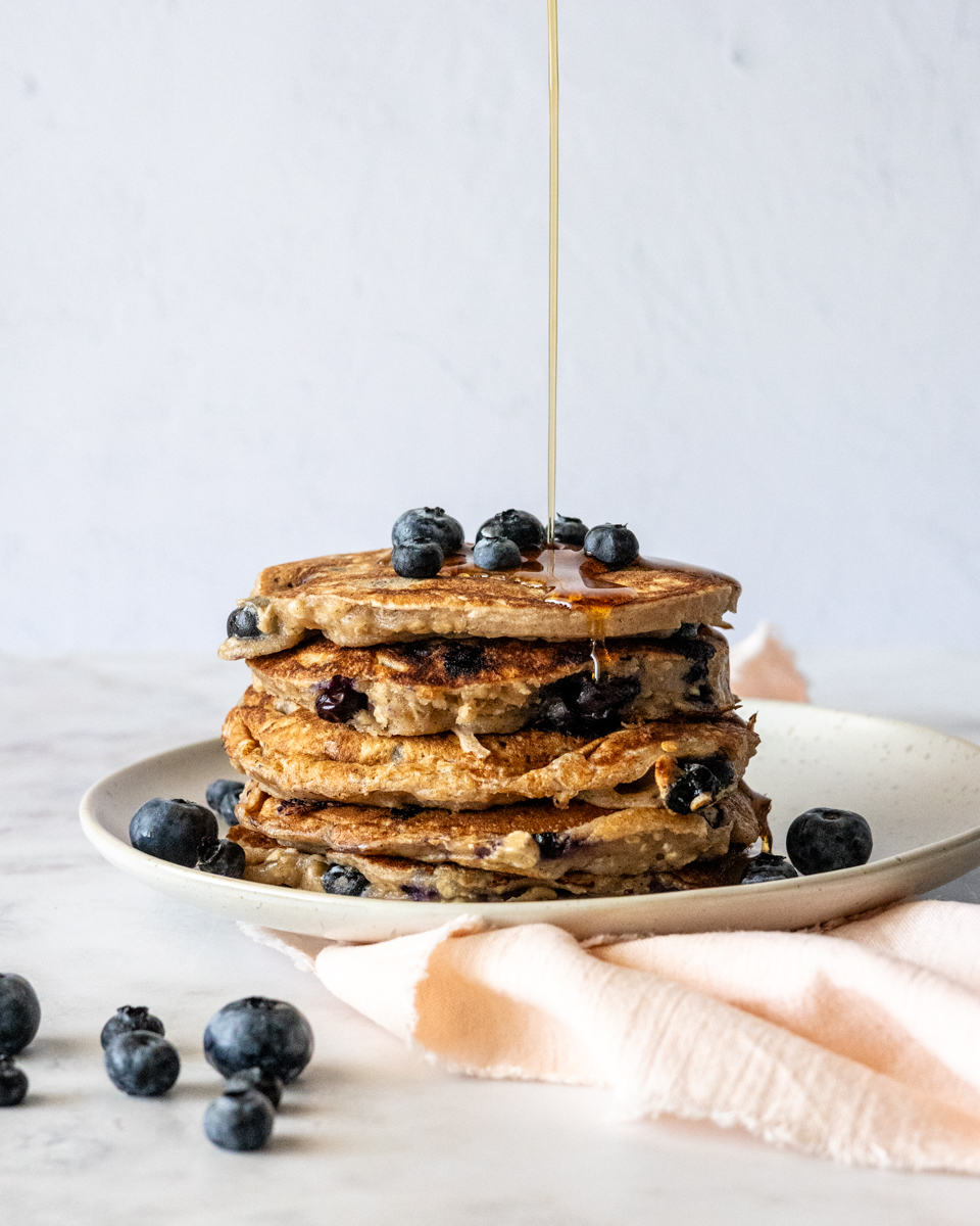 Blueberry oatmeal pancakes with maple syrup drizzle.